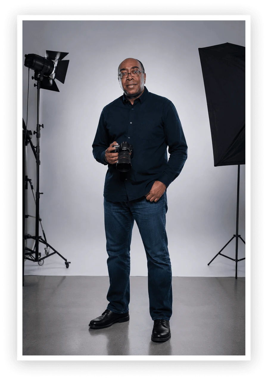 Marvin Hall, photographer, standing with his camera in his Lansing studio